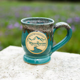 Handmade, ceramic teal with rust color 12 oz mug with Wild Rivers Logo and "Coffee for Conservation" on the center